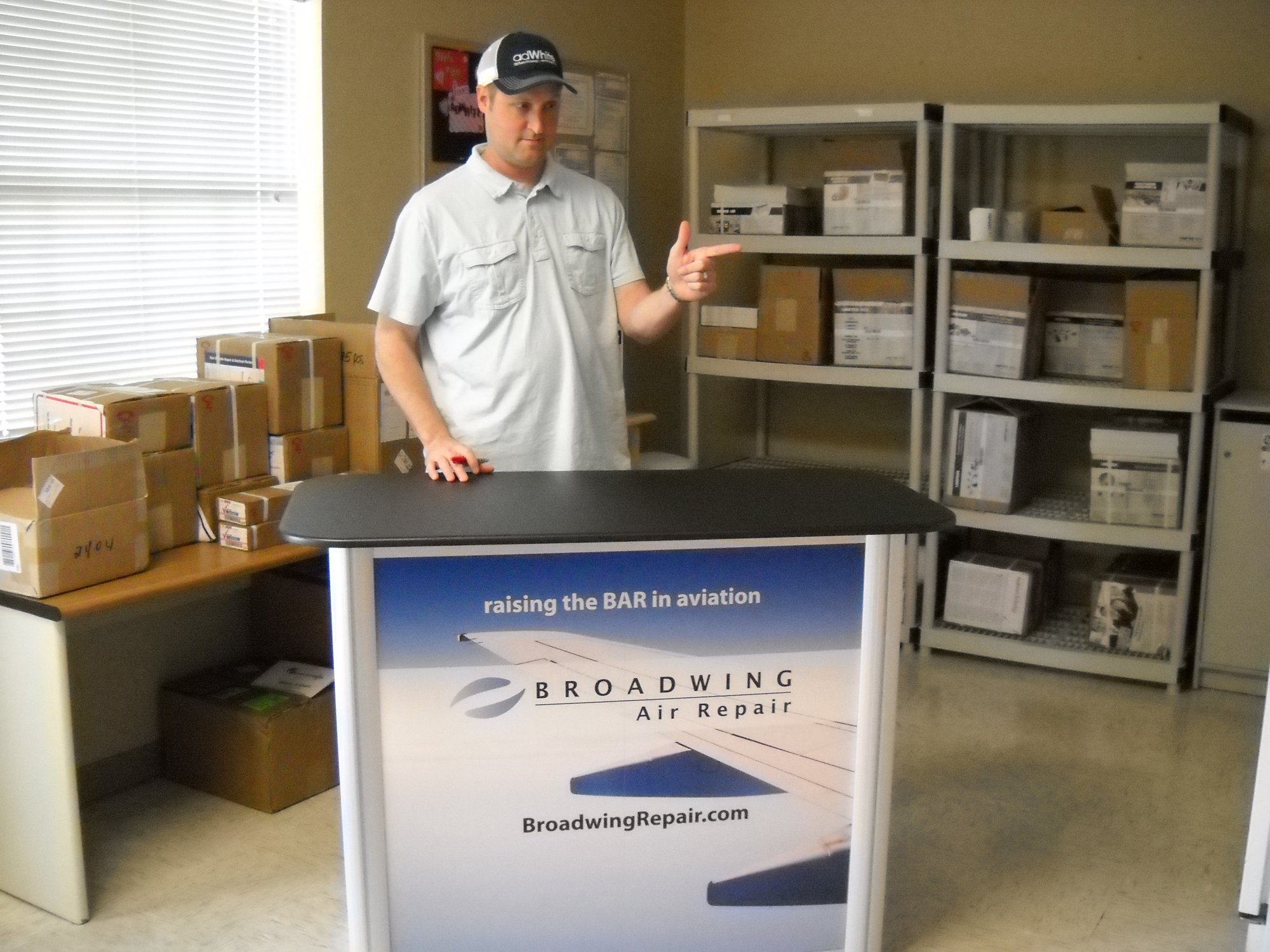 Taylor White in front of trade show booth counter